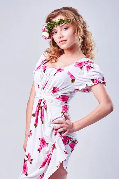 Menina beleza leva flores bonitas em suas mãos. A soprar flor. Penteado com flores. Retrato menina fantasia em cores pastel. Retrato de fadas de verão. Cabelo longo com permanente . — Fotografia de Stock