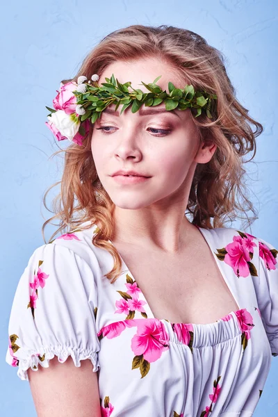 Menina beleza leva flores bonitas em suas mãos. A soprar flor. Penteado com flores. Retrato menina fantasia em cores pastel. Retrato de fadas de verão. Cabelo longo com permanente . — Fotografia de Stock