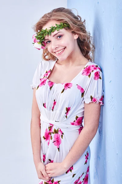 Menina beleza leva flores bonitas em suas mãos. A soprar flor. Penteado com flores. Retrato menina fantasia em cores pastel. Retrato de fadas de verão. Cabelo longo com permanente . — Fotografia de Stock