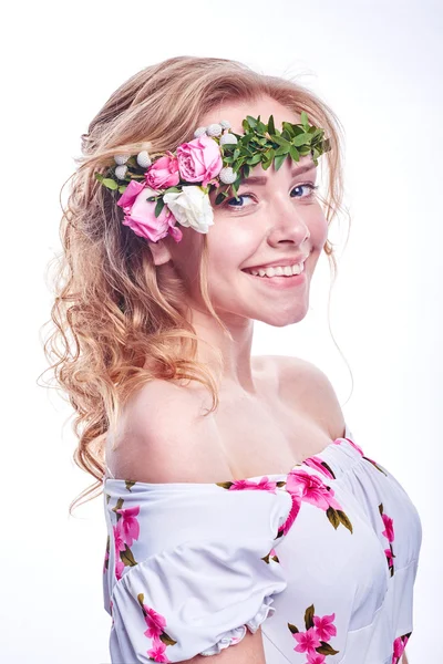 Menina beleza leva flores bonitas em suas mãos. A soprar flor. Penteado com flores. Retrato menina fantasia em cores pastel. Retrato de fadas de verão. Cabelo longo com permanente . — Fotografia de Stock