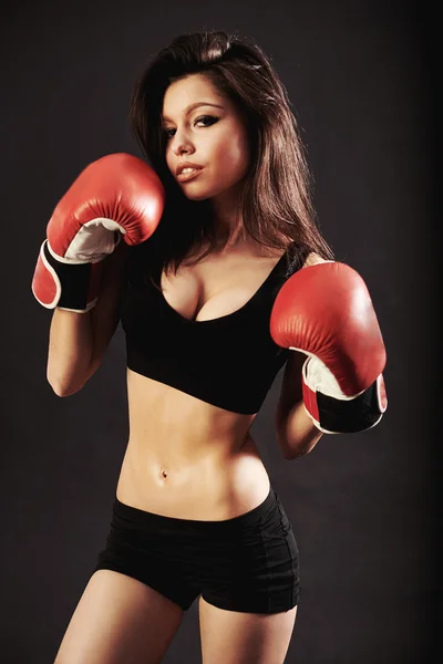 Mulher bonita com as luvas de boxe vermelho, fundo preto — Fotografia de Stock