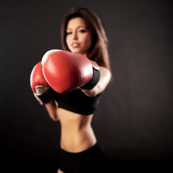 Kırmızı boks eldivenli, siyah arka planlı güzel bir kadın. — Stok fotoğraf