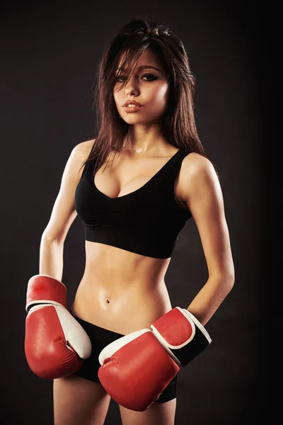 Mulher bonita com as luvas de boxe vermelho, fundo preto — Fotografia de Stock