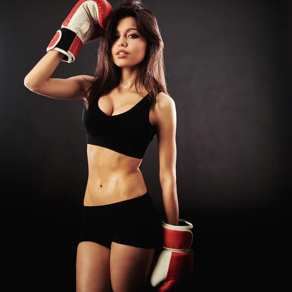 Hermosa mujer con los guantes de boxeo rojos, fondo negro — Foto de Stock