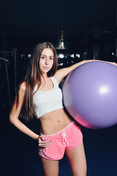 Chica de fitness posando en el banco en el gimnasio —  Fotos de Stock