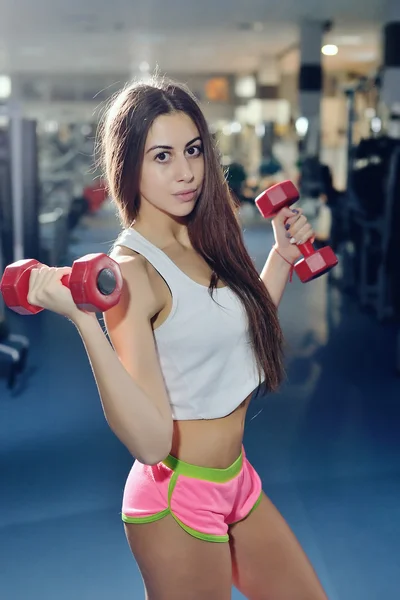 Chica de fitness posando en el banco en el gimnasio —  Fotos de Stock