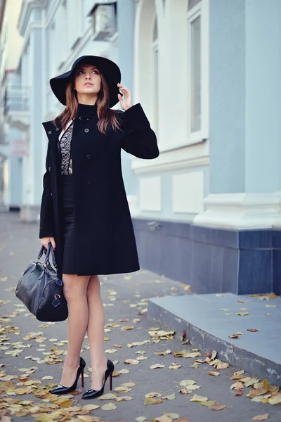 La jeune belle fille marche dans la rue avec un manteau et un chapeau w — Photo