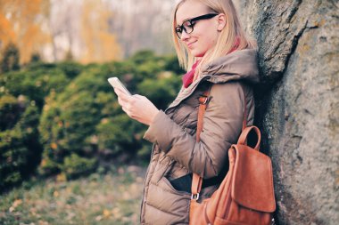 Bir öğrenci kız portresi. Gözlük ile dinlenme belgili tanımlık telefon 