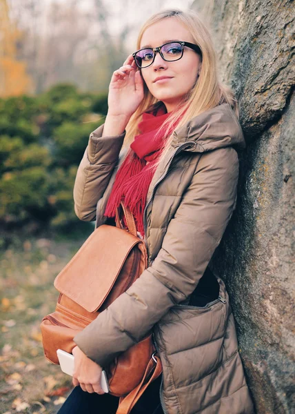 Belle étudiante avec un sac à dos, lunettes, en plein air . — Photo