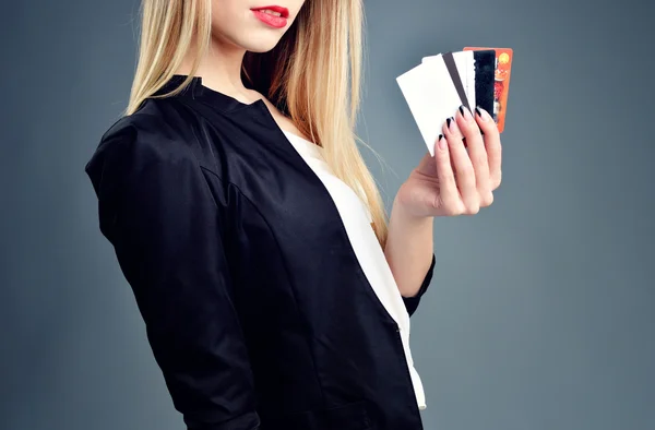 Bella amichevole sorridente ragazza fiduciosa mostrando cartellino rosso in mano, su sfondo blu — Foto Stock