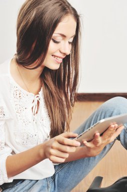 Neşeli hipster kadın işaret eden bir parmağa gri arka plan üzerinde tablet bilgisayar ekranında portresi