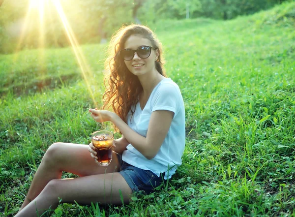 Giovane bella donna beve acqua da un bicchiere e mostrando pollici in su — Foto Stock