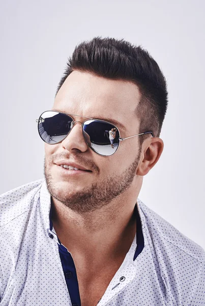 Closeup portrait of a casual young man with sunglasses looking at the camera. on gray background — Stock Photo, Image