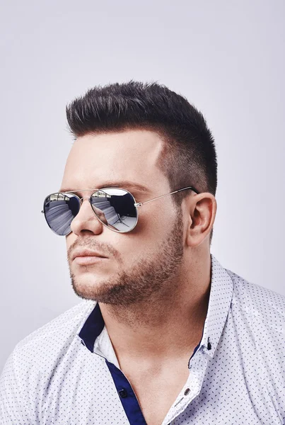 Closeup portrait of a casual young man with sunglasses looking at the camera. on gray background — Stock Photo, Image