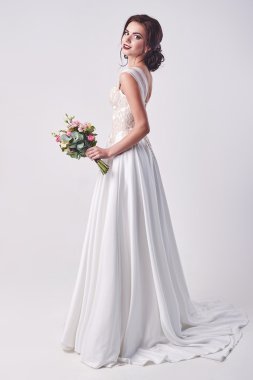 Beyaz gül buketiyle genç ve çekici bir gelin.