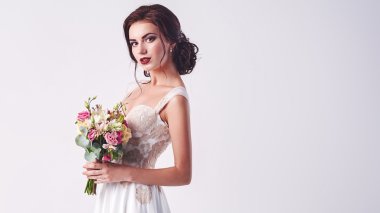 Beyaz gül buketiyle genç ve çekici bir gelin.