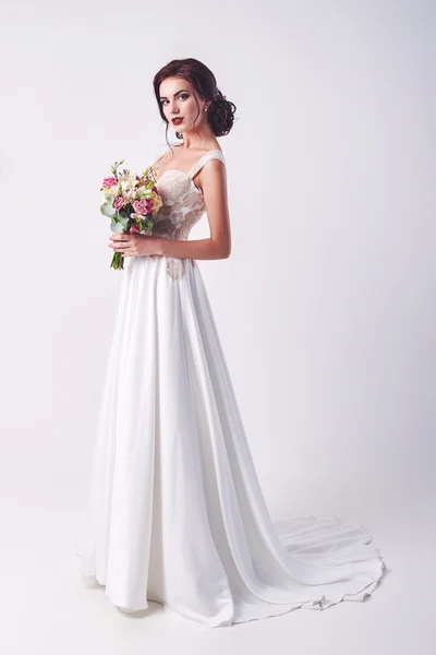 Jeune mariée attrayante avec le bouquet de roses blanches — Photo