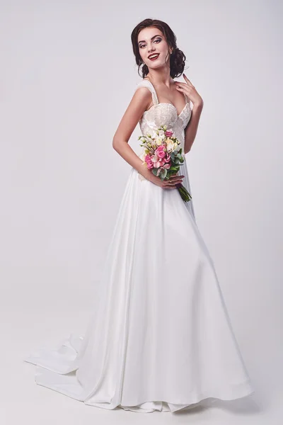 Mulher em vestido de noiva com buquê de flores . — Fotografia de Stock