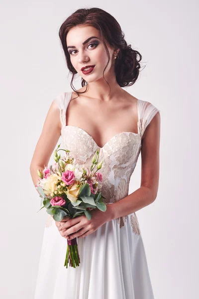 Νεαρή ελκυστική νύφη με το μπουκέτο από λευκά τριαντάφυλλα — Φωτογραφία Αρχείου