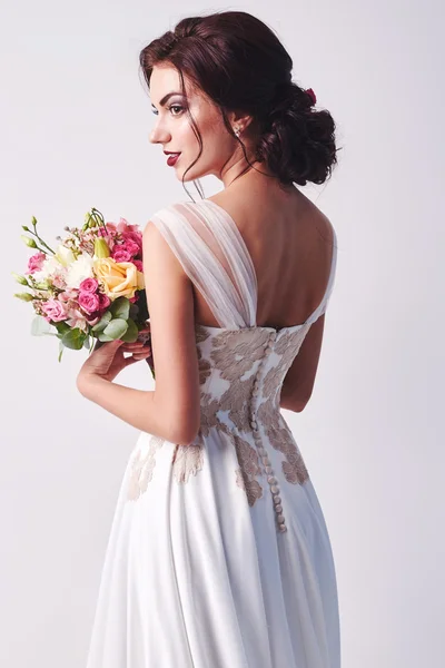 Woman in wedding dress with flowers' bouquet. — Stock Photo, Image