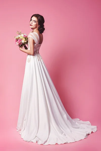 Bride.Young moda model mükemmel cilt ve makyaj, bej renkli arka plan, kıvırcık saç, saç çiçekleri
