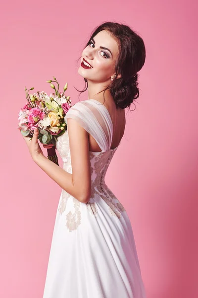 Moda bellezza modello ragazza con fiori capelli. Sposa. Trucco creativo perfetto e stile dei capelli. Acconciatura. Bouquet di bellissimi fiori — Foto Stock