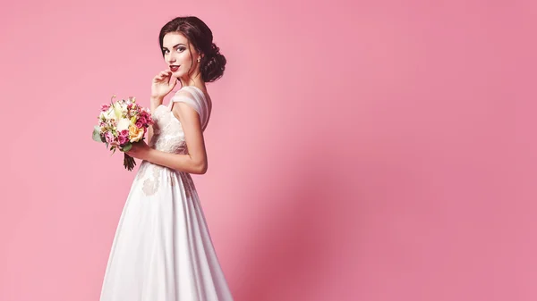 Bride.Young moda model mükemmel cilt ve makyaj, bej renkli arka plan, kıvırcık saç, saç çiçekleri