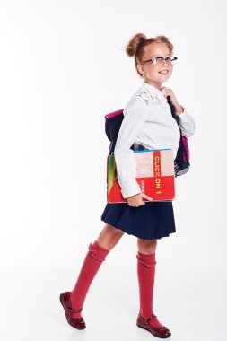 Portrait of teenager girl with school backpack holding colored folders isolated on white background