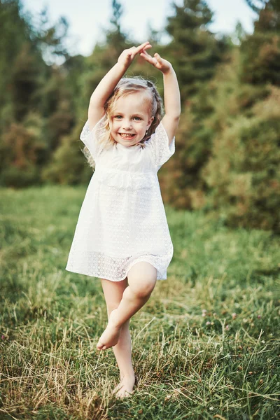 Malá holčička na louku s západ slunce — Stock fotografie