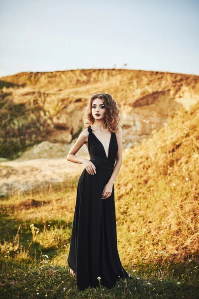 Menina fina muito bonita com cabelo longo em um vestido longo — Fotografia de Stock