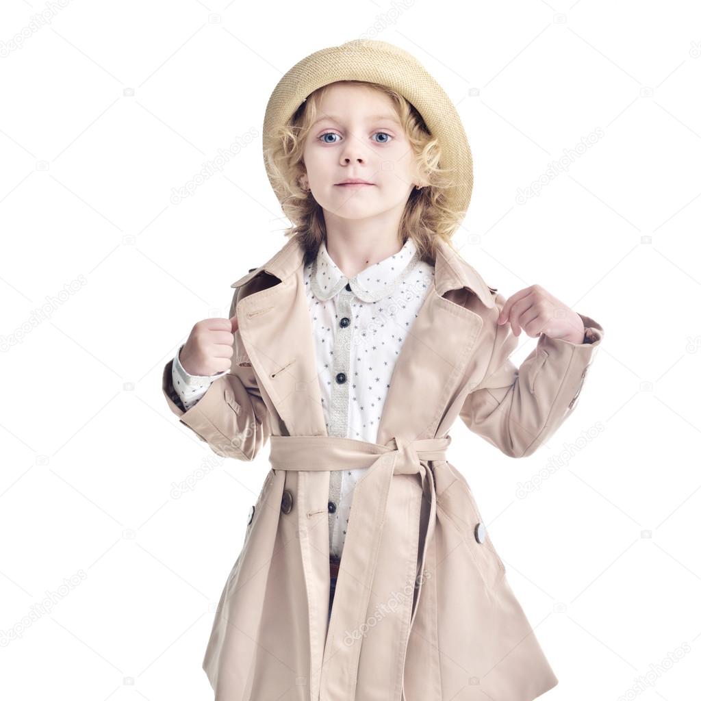 Fashionable child. Blonde girl in a stylish raincoat and hat.
