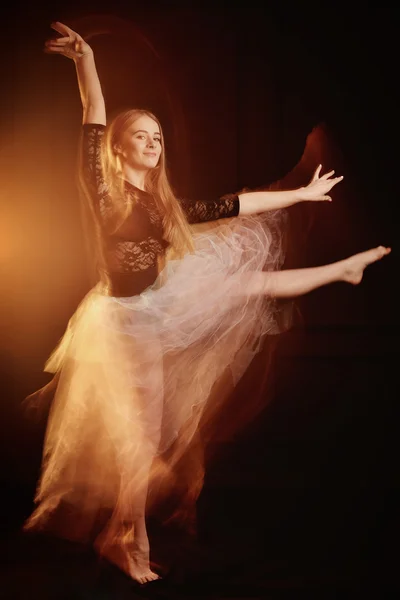 Молодая красивая танцовщица танцует и прыгает, студия — стоковое фото
