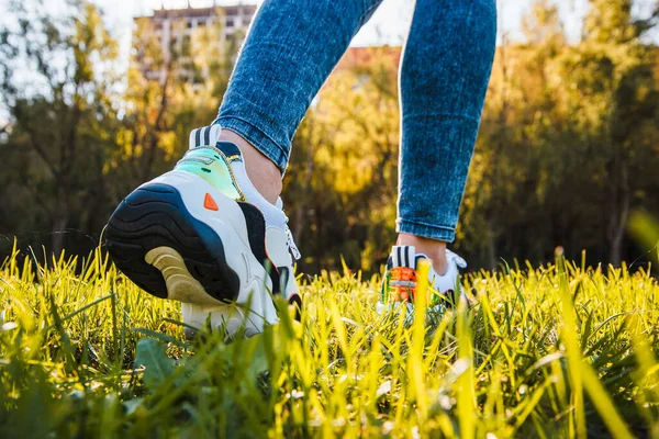 White Sneakers Black Inserts Female Legs Dressed Jeans Green Grass — Stock Photo, Image