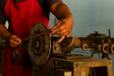 Keman el yayı ile yapılır. Bir zanaatkârın elleri bir tezgahta zımparalama ya da alet sapını şekillendirir. Görüntü, işçilik, el emeği ve geleneksel ahşap işçiliği veya metal işçiliği tekniklerini ön plana çıkarıyor. Müzik Enstrümanı aracı.