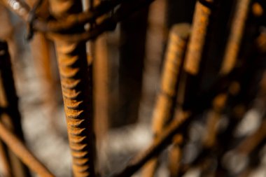 Güçlendirilmiş beton yapımında kullanılan paslı çelik demirin yakın çekimi. Resim, inşaat malzemelerinin yapı ve dokusunu gösterir..