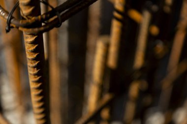 Güçlendirilmiş beton yapımında kullanılan paslı çelik demirin yakın çekimi. Resim, inşaat malzemelerinin yapı ve dokusunu gösterir..