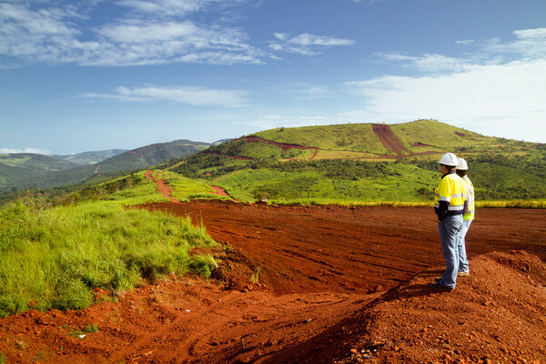 Mining construction workers surveying mountain top in Africa