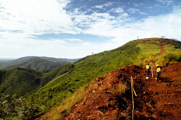 Trabajadores de la construcción minera que inspeccionan la cima de las montañas en África Imágenes De Stock Sin Royalties Gratis