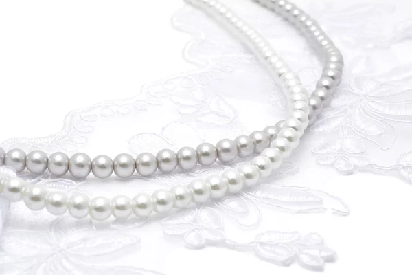 Beyaz dantel iplerde inci boncuk