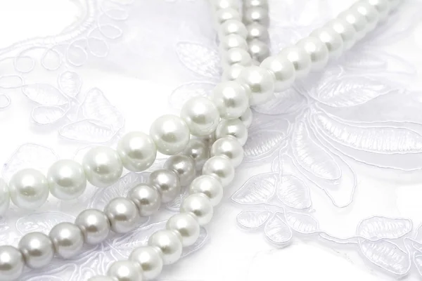 Perlenketten auf weißer Spitze — Stockfoto