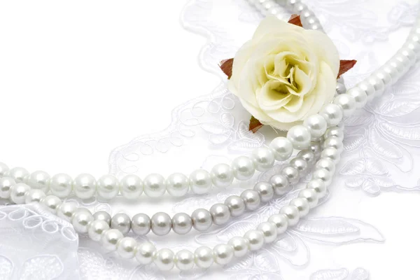 Pearl beads strings on white lace — Stock Photo, Image