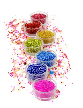 Satır cam beyaz arka plan üzerinde renkli boncuk dolu kase