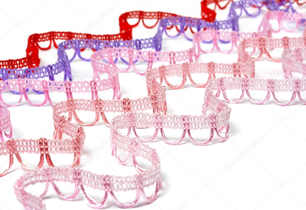 Curved strips of reddish lace on white background