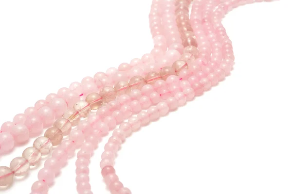 Cuerdas de cuarzo rosa para hacer joyas sobre fondo blanco —  Fotos de Stock