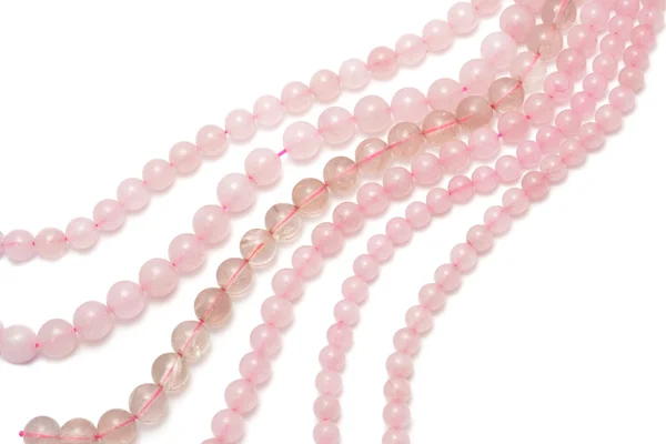 Strings of pink quartz for making jewellery on white background — Stock Photo, Image