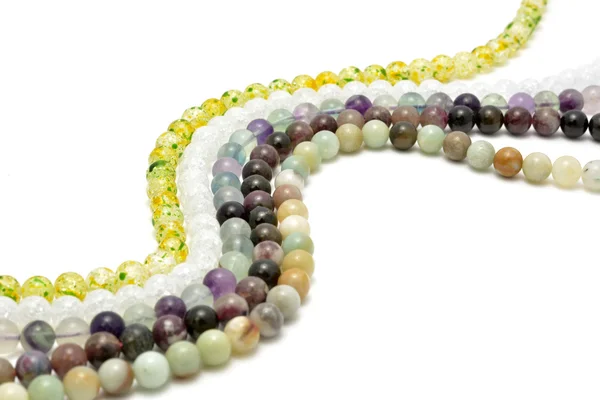 Cordas de pedras preciosas para fazer jóias sobre fundo branco — Fotografia de Stock