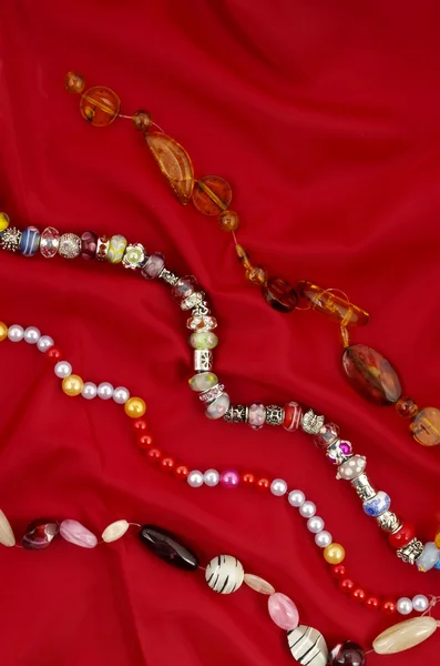 Cordes de perles sur fond textile rouge — Photo