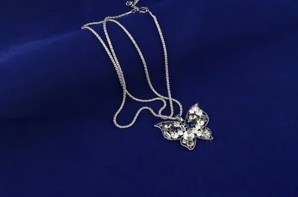 Silver butterfly mode smycken med strass på blå mirrorlike bakgrund — Stockfoto