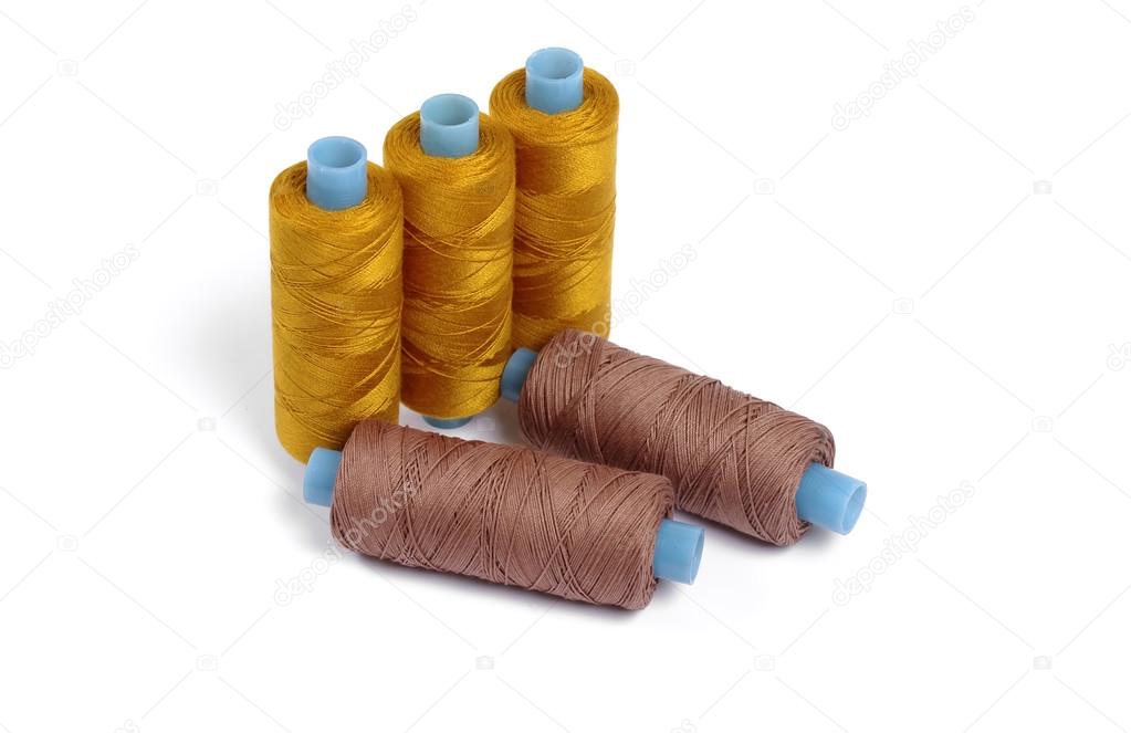 Five sewing spools on white backgrouns - brown and orange
