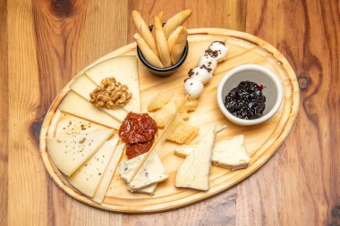 Yukarıdan bakıldığında tipik bir peynir masası. Kurutulmuş domates, reçel, ceviz ve çivili ekmek.